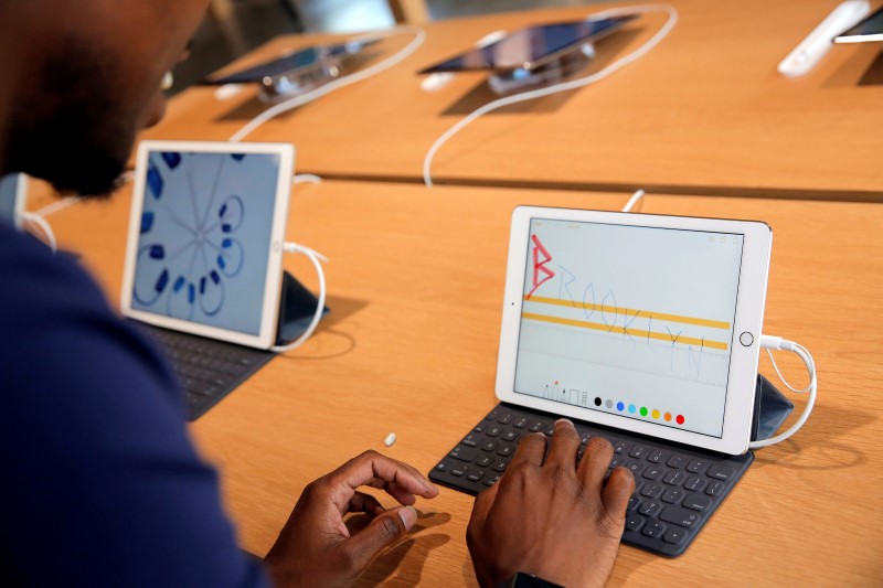 © Reuters. A store employee uses an iPad during a preview event at the new Apple Store Williamsburg in Brooklyn, New York