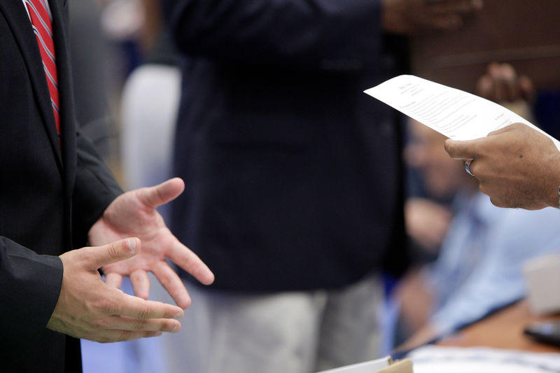 © Reuters. A job seeker talks with a corporate recruiter as he peruses the man's resume at a Hire Our Heroes job fair in Washington