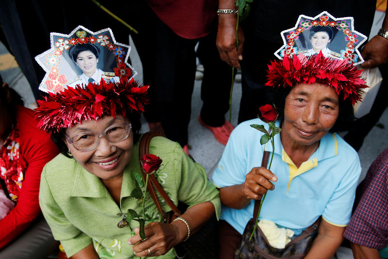 © Reuters. Supporters of former Thai Prime Minister Shinawatra wait for her outside the Supreme Court in Bangkok