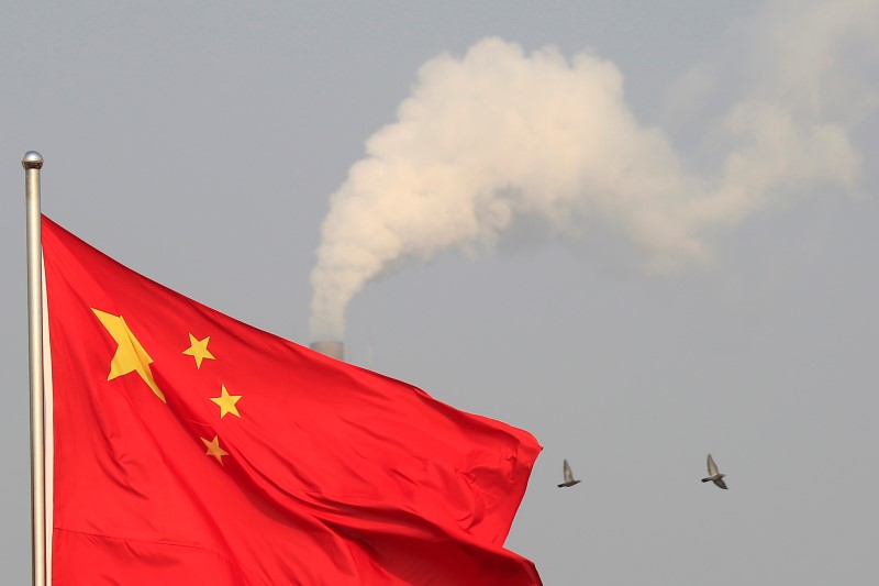 © Reuters. Birds fly past the chimney of a thermal power plant as China's national flag flutters in a suburb in Shanghai
