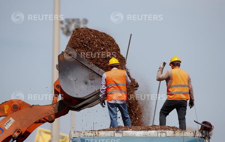 © Reuters. Uomini al lavoro al porto di Augusta, in Sicilia.