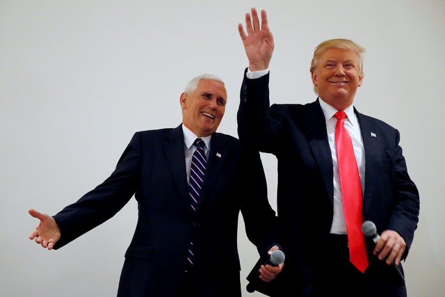 © Reuters. Republican presidential candidate Donald Trump and vice presidential candidate Mike Pence speak in an overflow room at a campaign event in Roanoke