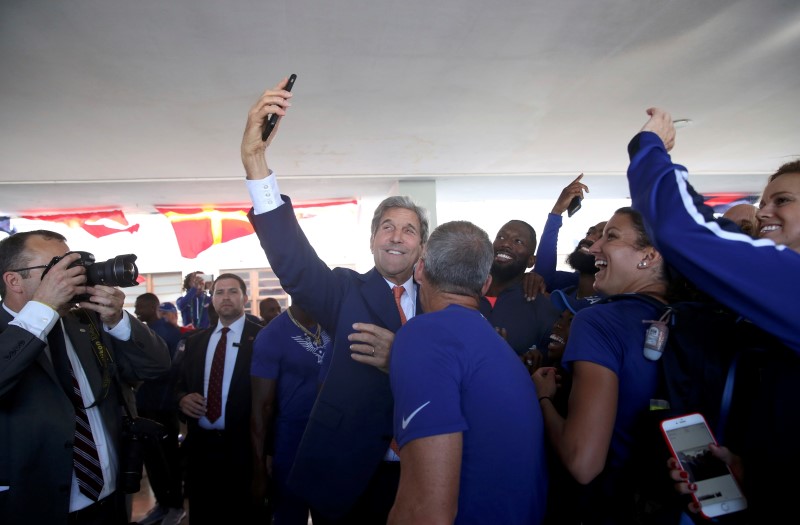 © Reuters. U.S. Secretary of State John Kerry takes a selfie with members of the U.S. Olympic team at the Brazilian Naval Academy