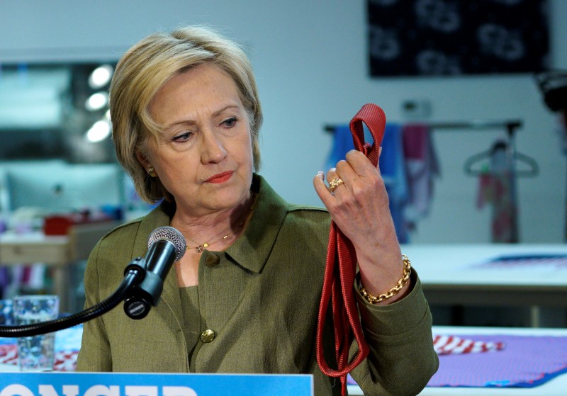 © Reuters. U.S. Democratic presidential nominee Hillary Clinton looks at a Donald Trump brand tie made in China during a stop at a local tie company in Denver