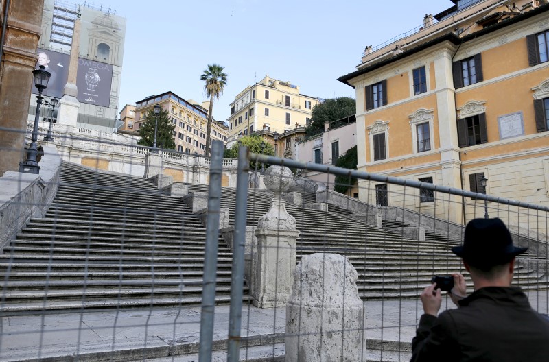 © Reuters. A man takes a picture through a barrier at the bottom of the Spanish Steps in Rome