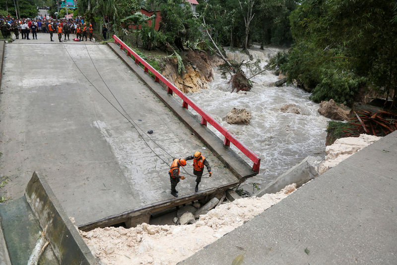 © Reuters. Members of Guatemalan emergency commission (CONRED) stand at a bridge that collapsed after heavy rains brought by Hurricane Earl at Menchor de Mencos