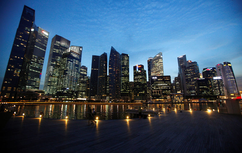 © Reuters. People walk past the skyline of Marina Bay central business district in Singapore