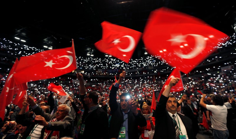 © Reuters. Supporters of Turkish Prime Minister Erdogan hold up their mobile phones and wave Turkish flags ahead of his visit in Lanxess Arena in Cologne