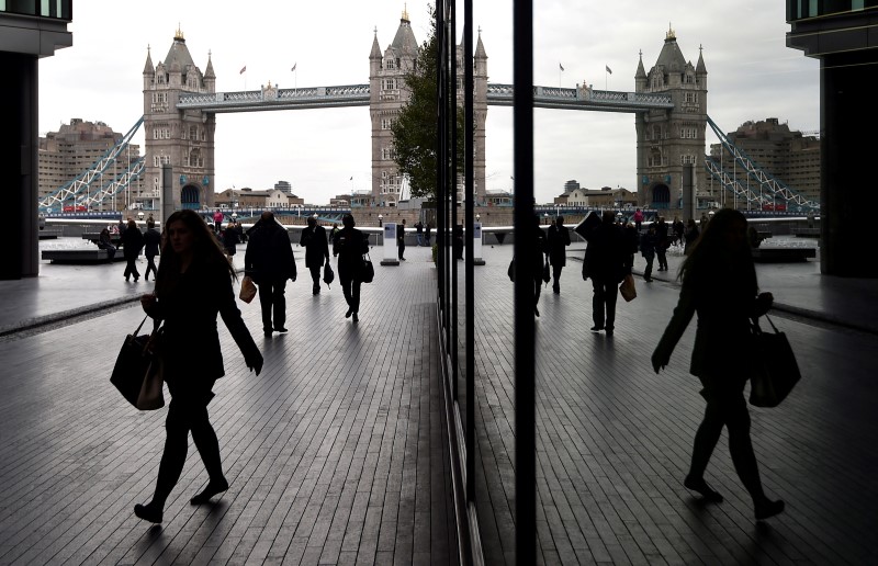 © Reuters. File photo  of workers walking through the More London business district with Tower Bridge seen behind in London