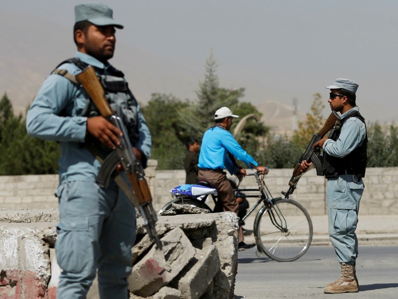 © Reuters. Afghan policemen stand guard at a checkpoint near the site of kidnapping in Kabul,