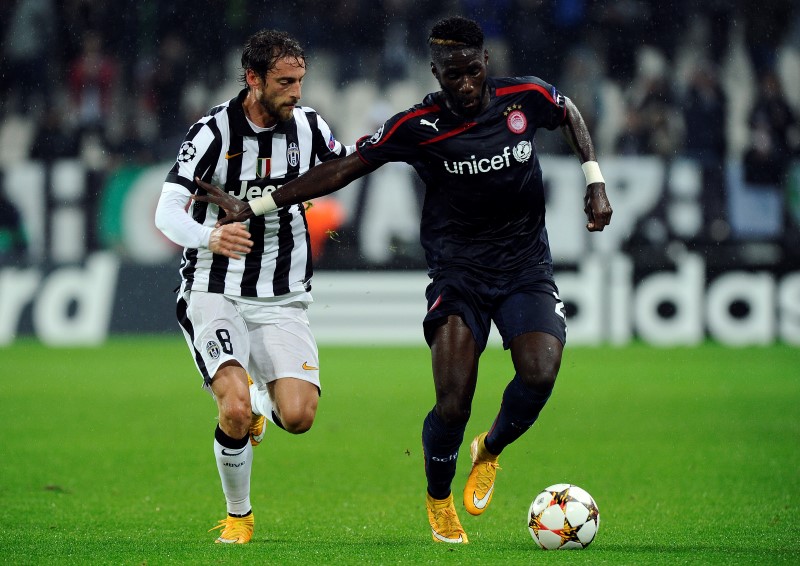 © Reuters. Olympiakos' Masuaku fights for the ball with Juventus' Marchisio during their Champions League soccer match at Juventus stadium in Turin