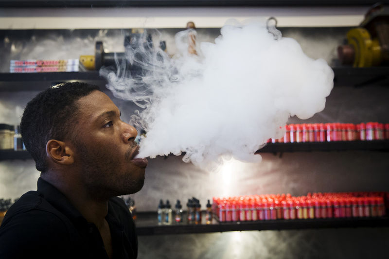 © Reuters. A sales clerk exhales vapor while smoking with a vaporizer during a wait for customers at the Henley Vaporium in New York