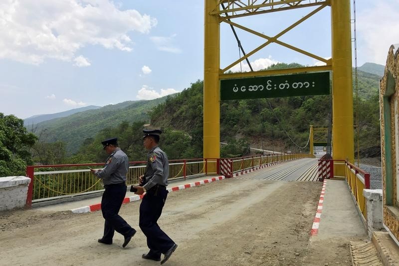 © Reuters. Myanmar police survey a bridge in Myanmar's Chin state, near the border with India