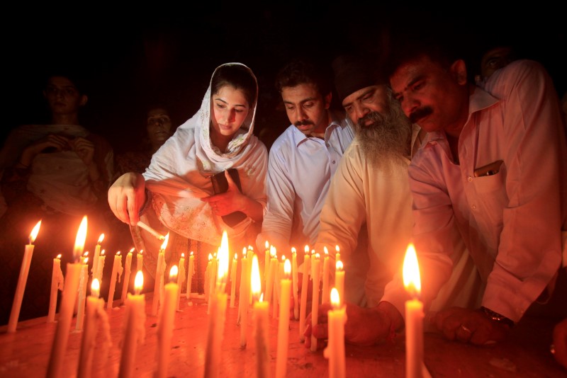 © Reuters. Residents light candles to honour victims of the blast in Quetta during a candellight vigil in Peshawar