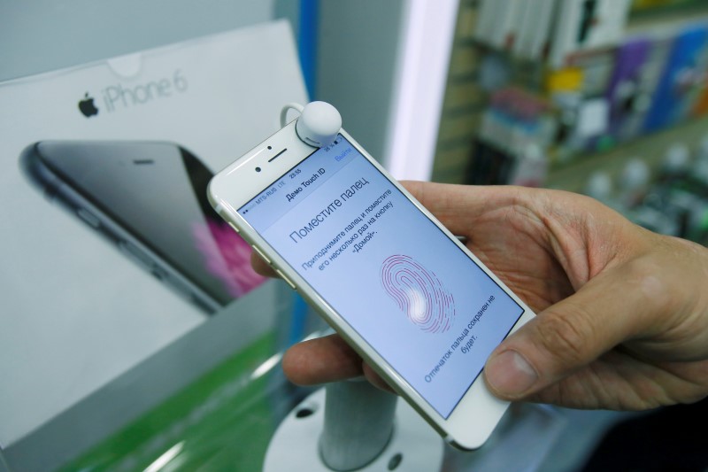 © Reuters. A man holds an iPhone 6 in a mobile phone shop in Moscow