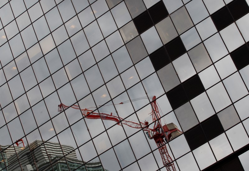 © Reuters. A crane on a construction site is reflected in office windows in Birmingham, central England