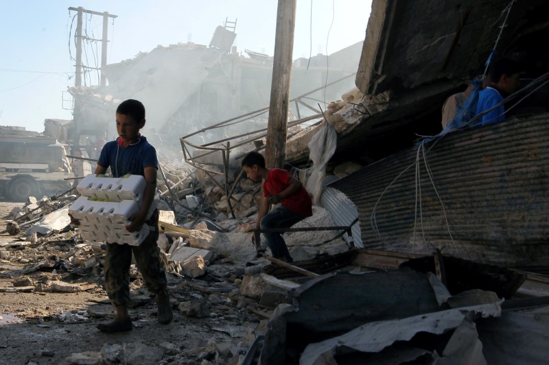 © Reuters. Meninos em meio a destroços na região síria de Aleppo