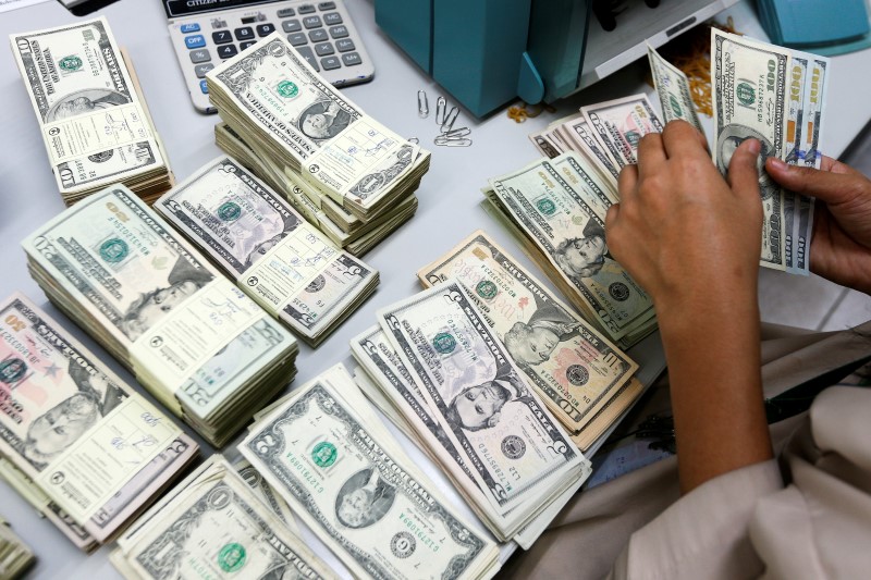 © Reuters. A bank employee counts U.S. dollar notes at a Kasikornbank in Bangkok