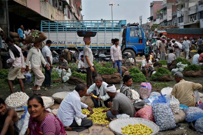 © Reuters. Vendors and customers crowd at a wholesale vegetable and fruit market in New Delhi