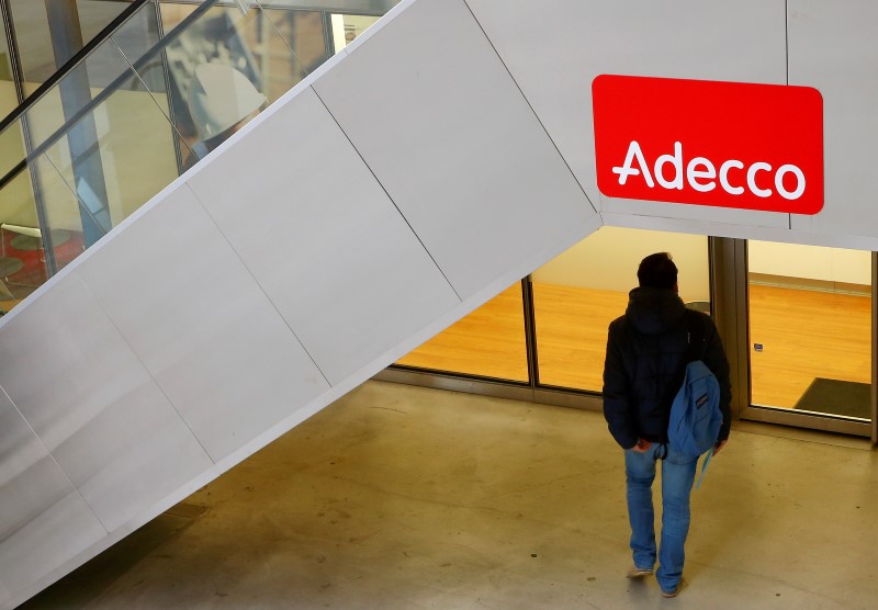 © Reuters. A man walks in front of a branch of Swiss staffing group Adecco in Zurich