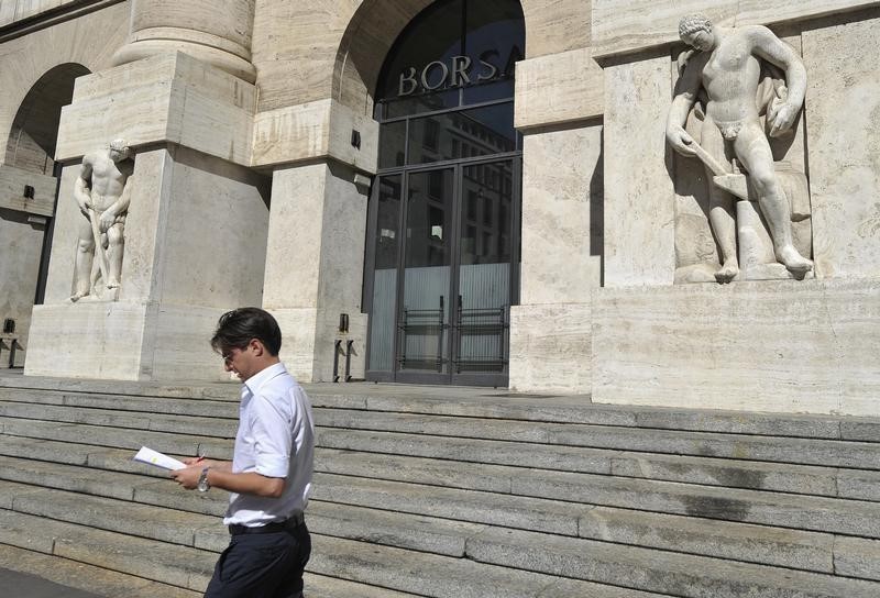 © Reuters. Uomo davanti all'ingresso della Borsa di Milano.