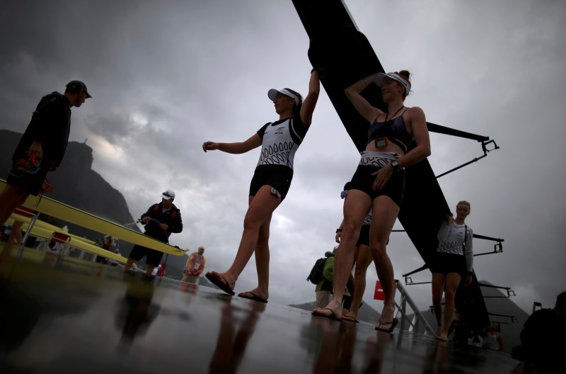 © Reuters. New Zealand (NZL) Women's Eight team carry their boat from the water after the competition got postponed due to bad weather in Rio De Janeiro