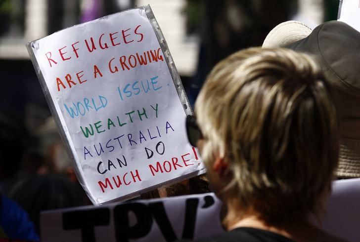 © Reuters. Manifestante segurando cartaz em protesto para ajuda de refugiados em Sydney