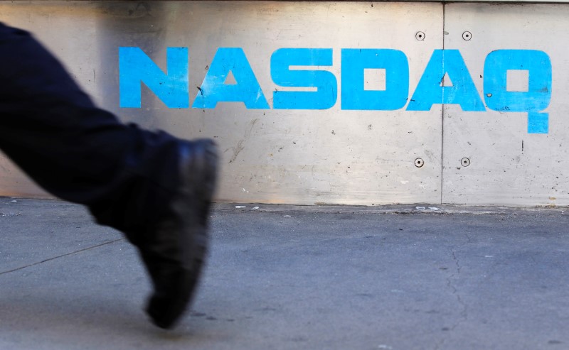 © Reuters. A pedestrian walks past the NASDAQ building in New York City