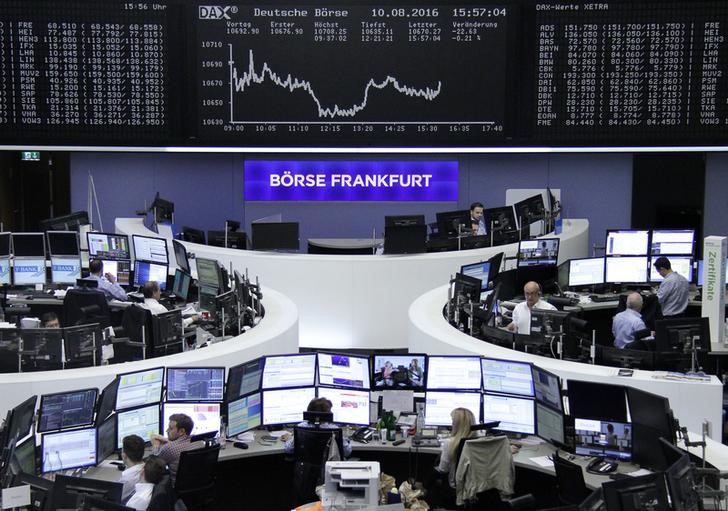 © Reuters. Traders work at their desks in front of the German share price index DAX board in Frankfurt