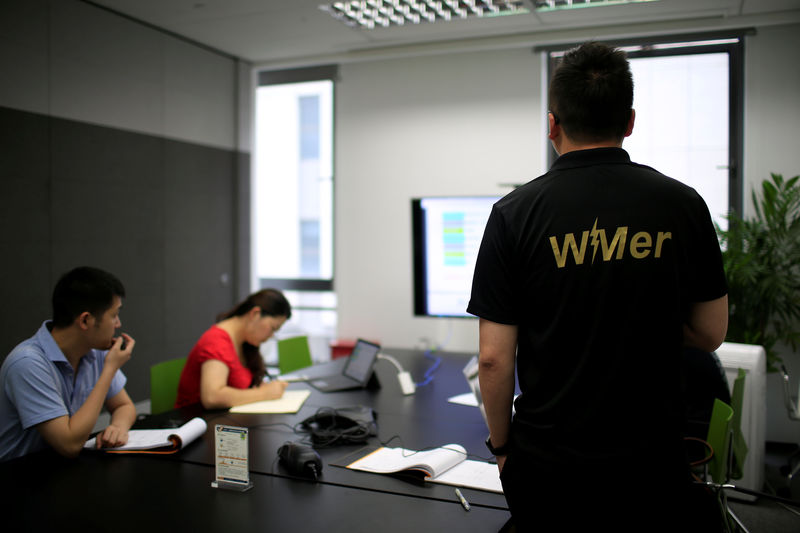 © Reuters. Employees of WM Motor Technology Co., Ltd. work at their office in shanghai