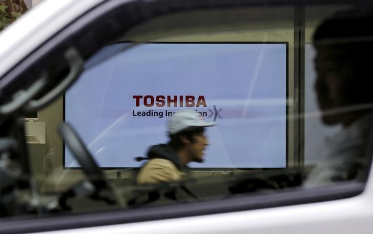 © Reuters. A Toshiba Corp logo displayed on one of its television sets is seen through a vehicle in Tokyo, Japan