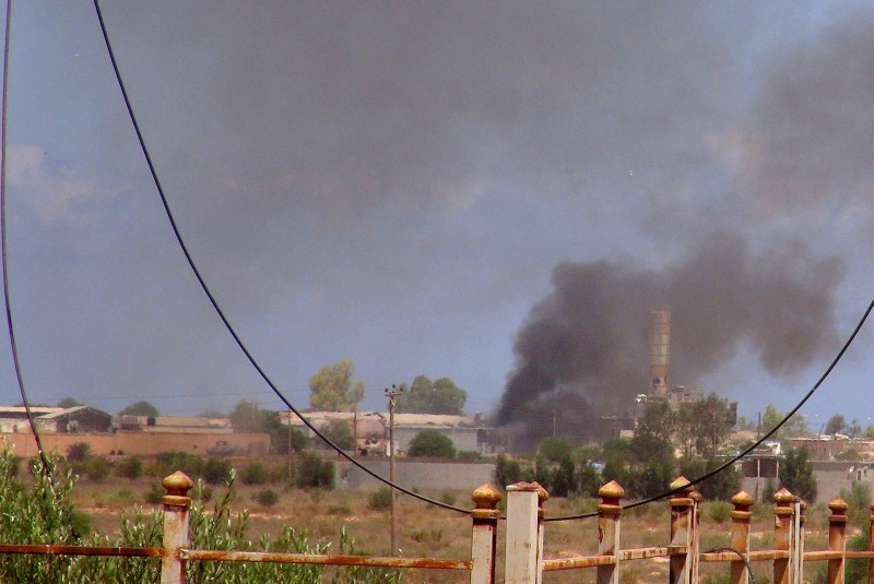 © Reuters. Smoke rises following an air strike as Libyan forces allied with the U.N.-backed government battle with IS fighters to capture university buildings in Sirte