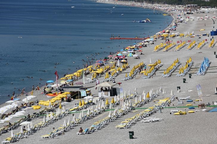 © Reuters. Tourists enjoy a beach in the Mediterranean resort city of Antalya