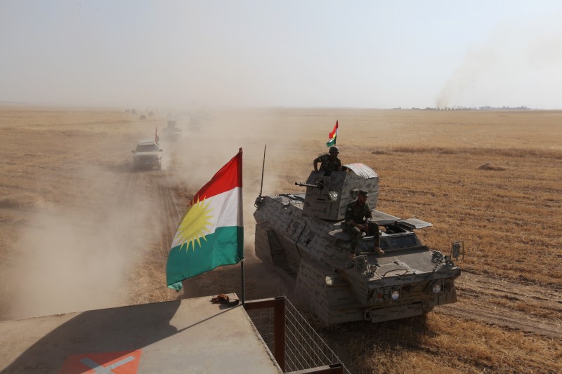 © Reuters. A Kurdish flag is seen on military vehicles of the Kurdish Peshmerga forces on the southeast of Mosul