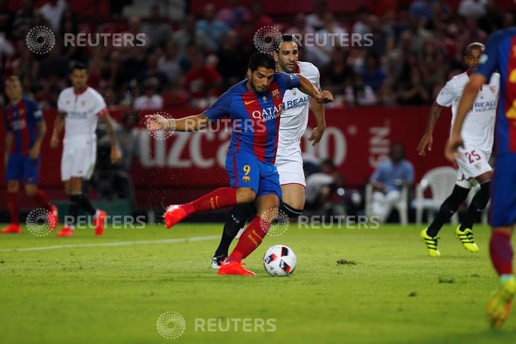 © Reuters. El delantero del Barcelona Luis Suárez patea para anotar un gol en el primer partido de la final por la Supercopa de España de Fútbol ante Sevilla