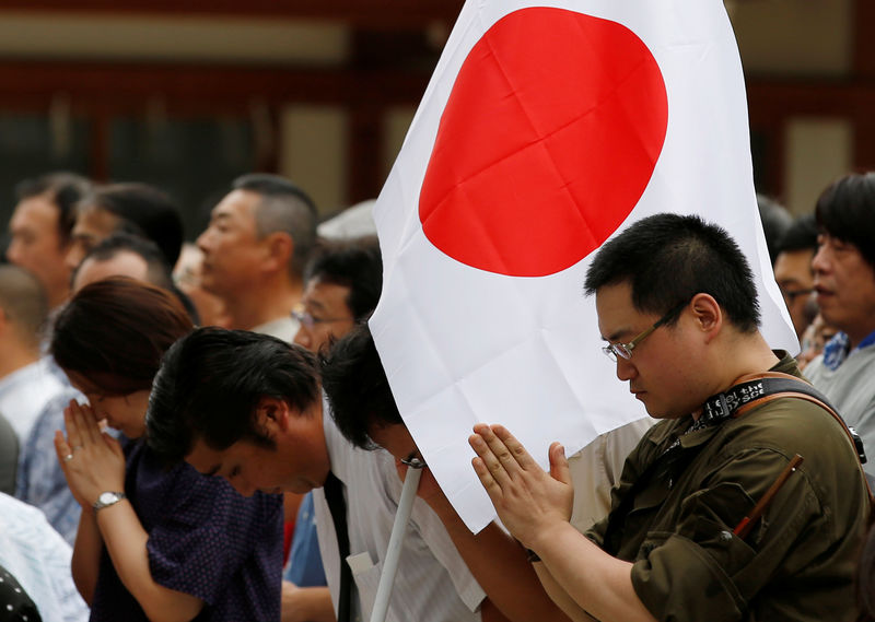 © Reuters. Visitors pray at Yasukuni Shrine on the anniversary of Japan's surrender in World War Two in Tokyo