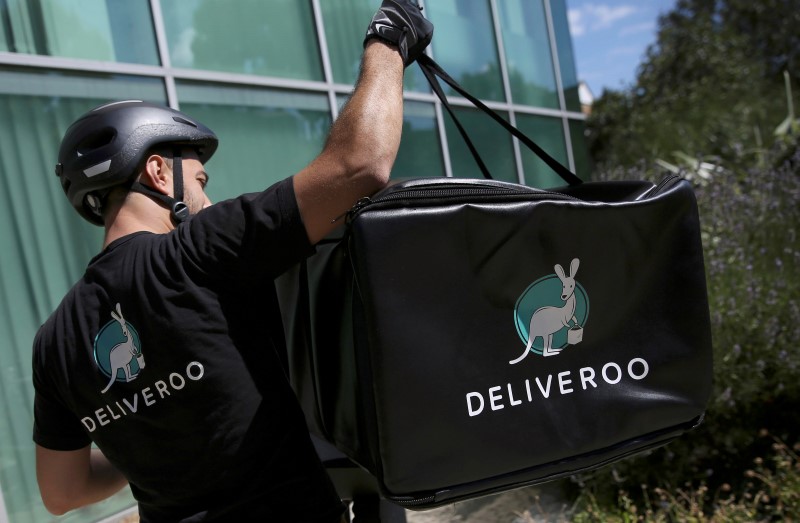 © Reuters. A Deliveroo worker loads his bicycle after making a delivery in London