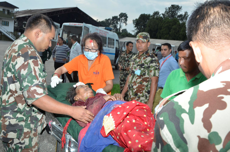 © Reuters. Nepalese army personnel assist a victim of a bus accident after being airlifted from Birtadeurali in Kavre to Kathmandu