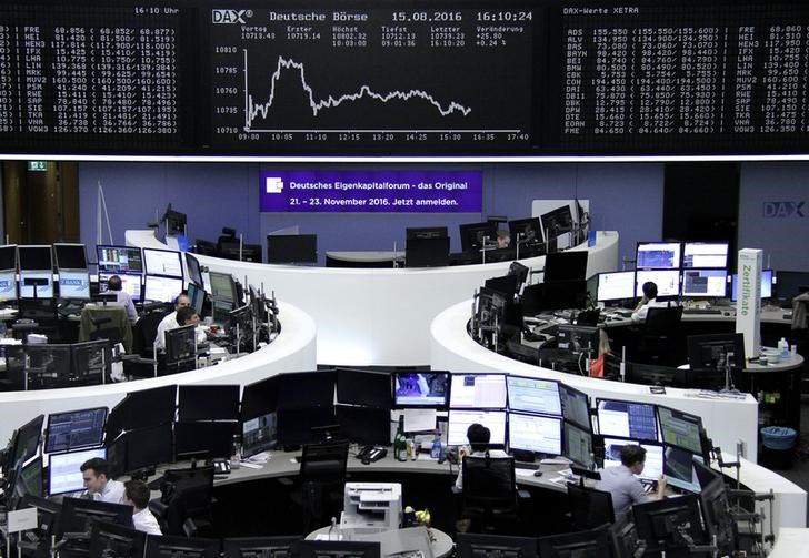 © Reuters. Traders work at their desks in front of the German share price index DAX board in Frankfurt