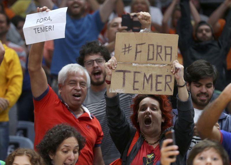 © Reuters. Espectadores de partida de vôlei feminino seguram cartazes em que se lê "Fora Temer