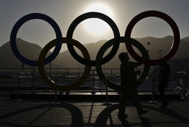 © Reuters. Homem pega bola de tênis perto dos anéis olímpicos no Parque Olímpico do Rio de Janeiro