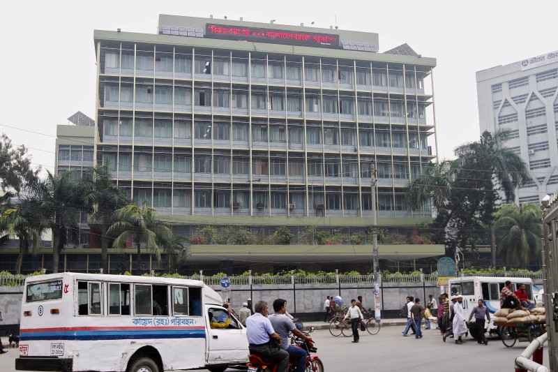 © Reuters. Commuters pass by the front of the Bangladesh central bank building in Dhaka