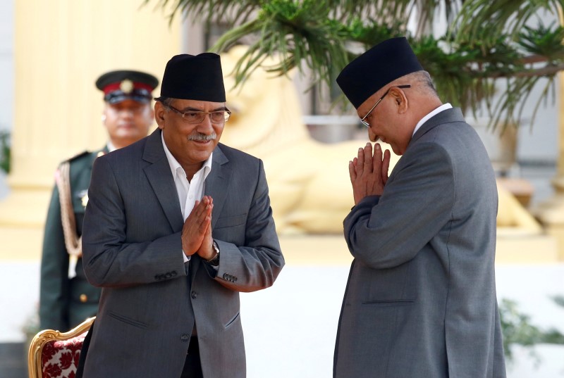 © Reuters. Newly elected Nepalese PM Pushpa Kamal Dahal greets outgoing Prime Minister Khadga Prasad Sharma Oli (R) upon their arrival at the presidential building "Shital Niwas" in Kathmandu