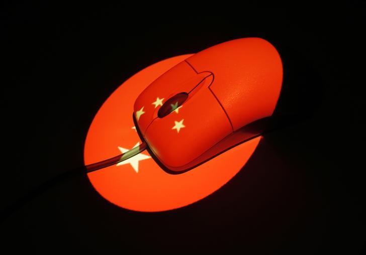 © Reuters. Photo illustration of a computer mouse illuminated by a projection of a Chinese flag