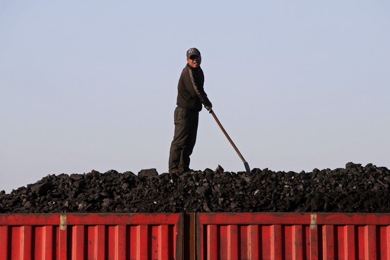 © Reuters. A worker speaks as he loads coal on a truck at a depot near a coal mine from the state-owned Longmay Group on the outskirts of Jixi, Heilongjiang, China