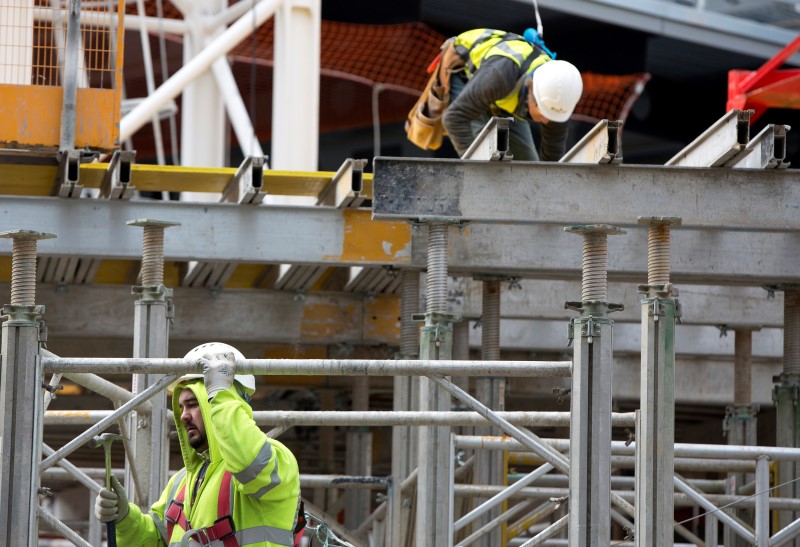 © Reuters. Construction workers work on a site in London