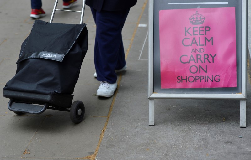 © Reuters. Shoppers walk pass a retail sign that reads 