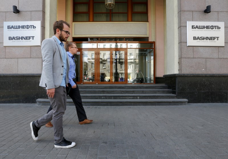 © Reuters. Men walk past headquarters of Russian state-owned oil producer Bashneft in Moscow