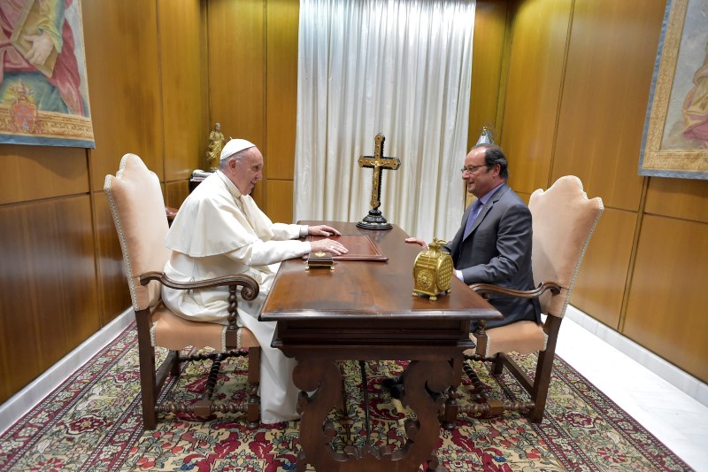 © Reuters. Pope Francis talks to French President Hollande at the Vatican