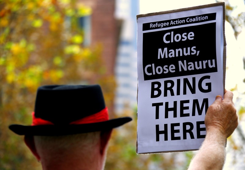 © Reuters. A protester from Refugee Action Coalition holds placard during demonstration outside offices of the Australian Government Department of Immigration and Border Protection in Sydney, Australia